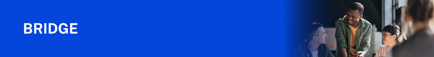 Three people conversing around a table, with a laptop and papers in view.